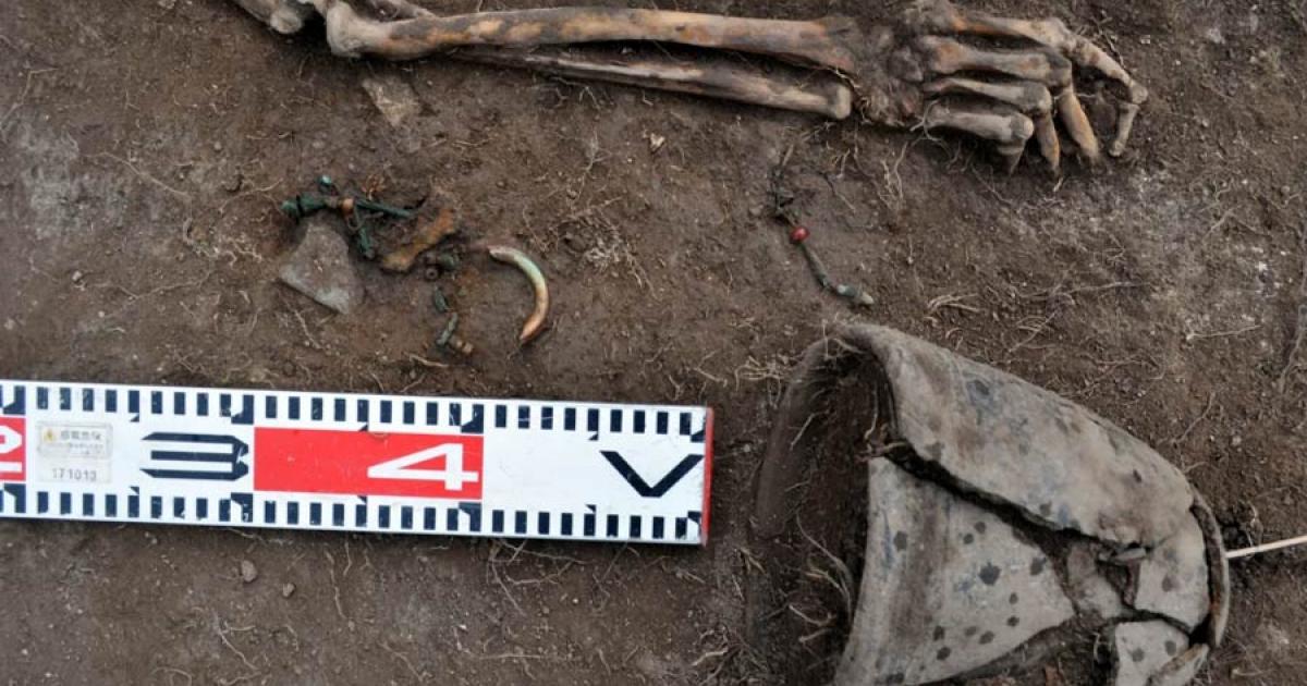 A closeup of the Tagar female grave (excavated in the Siberian steppe Minusinsk basin), which is an anomaly because the bone amulet next to her wrist is made with one piece of human bone, suggesting secondary burial grave manipulation.		Source: Evgeniy Bogdanov / Haaretz