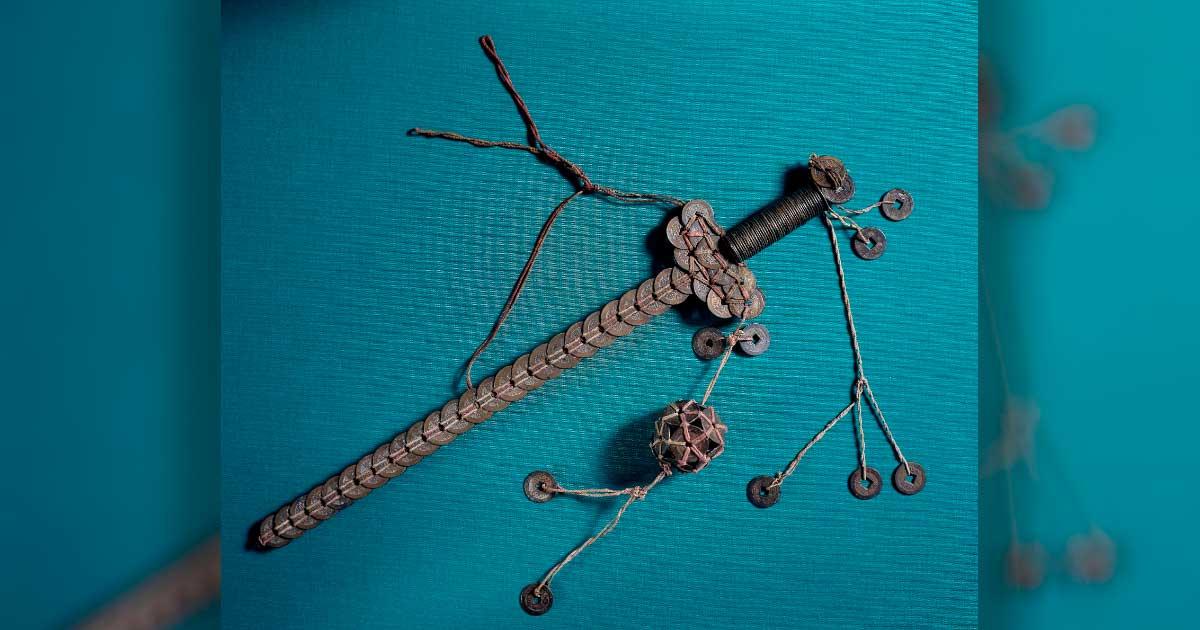 Coin sword made of an iron rod with Chinese cash coins of the 19th century tied to it with red and green string in the shape of a sword, with hanging ornaments. Source: British Museum / CC BY NC SA 4.0