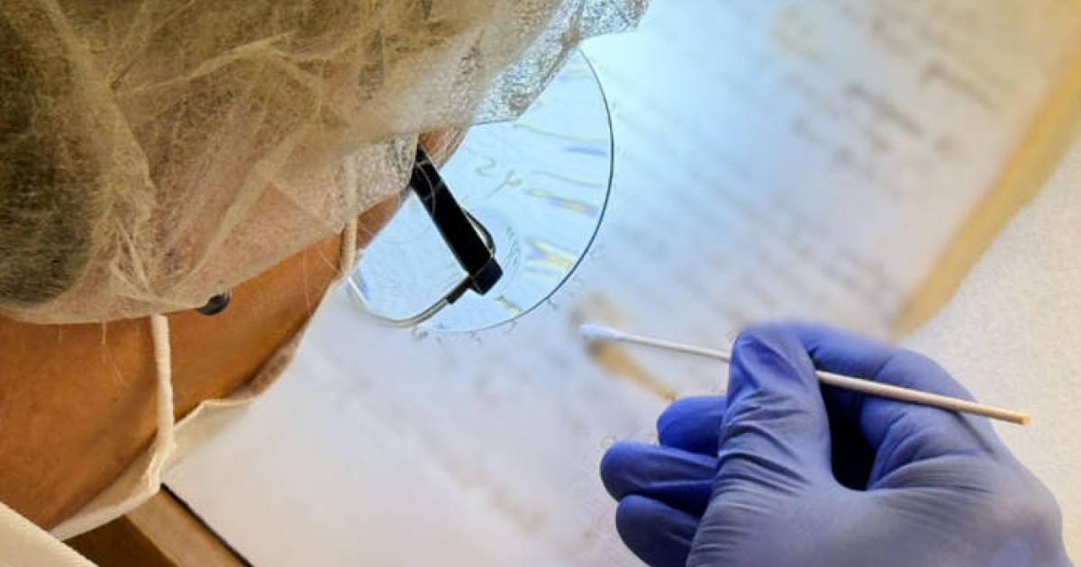 Artist Karina Åberg swabs a 14th century da Vinci family letter from the State Archive in Prato