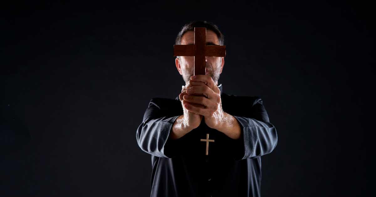 Priest conducting an exorcism. Source:  lunamarina / Adobe Stock