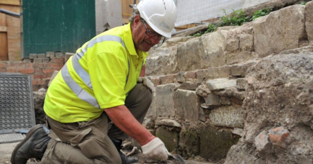 Cotswold Archaeology worker excavating in the area where the medieval graves and other artifacts were discovered. 