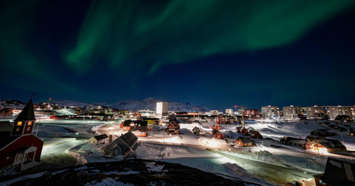 Nuuk, Greenland skyline with the aurora borealis shining overhead.