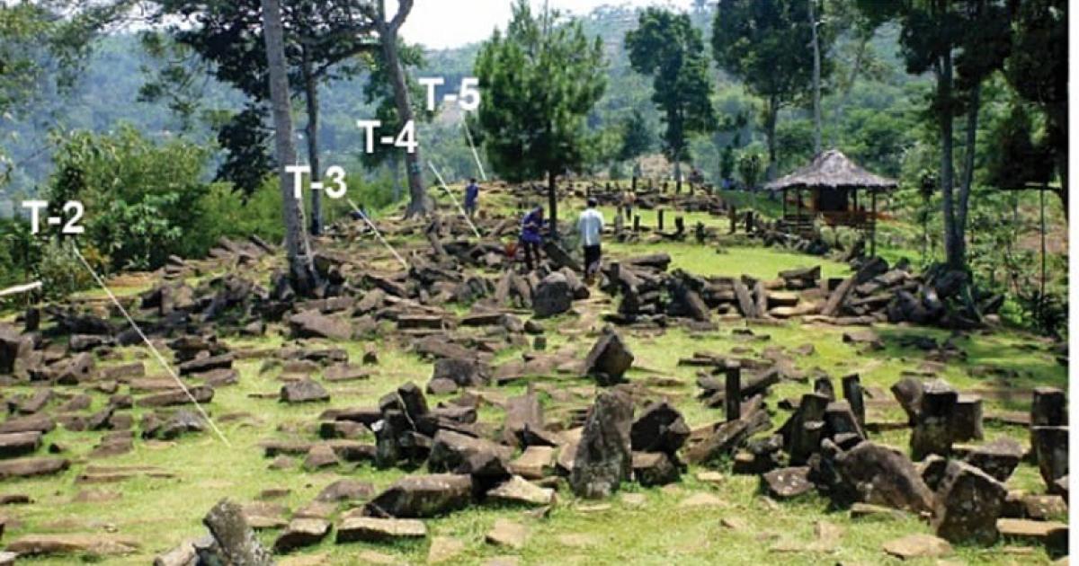 Grassy hilltop terrace scattered with dark columnar andesite blocks, with labels T-2 to T-5