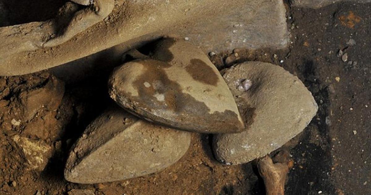 Three of the hearts in their urns on top of the earth in which they were buried 