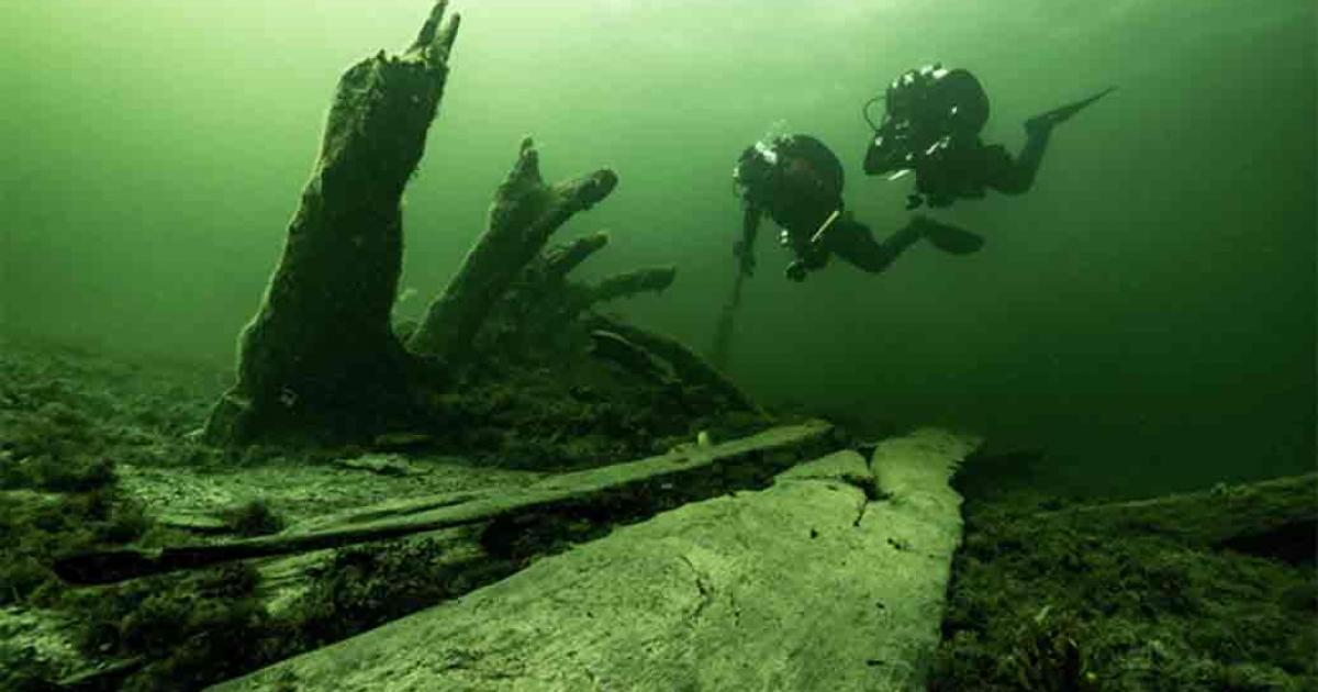 The authors at the stern of the wreck where the standing bottom logs and stern are seen sticking up from the seabed, seen from the starboard side. Source: Florian Huber/Stockholm University.
