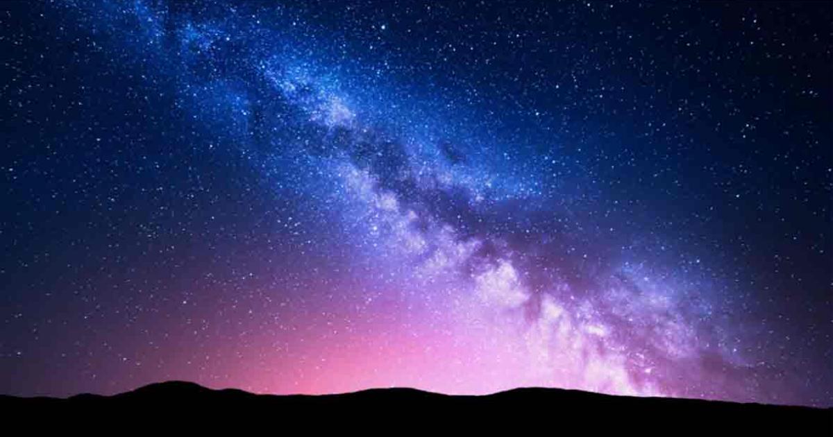 Milky Way and pink light over mountains. Source: den-belitsky/Adobe Stock