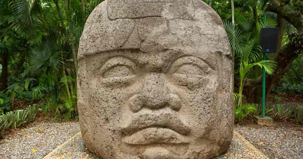 Large pre-Hispanic Olmec basalt carved head in the La Venta archeological park in Villahermosa Mexico.	Source: Barna Tanko
