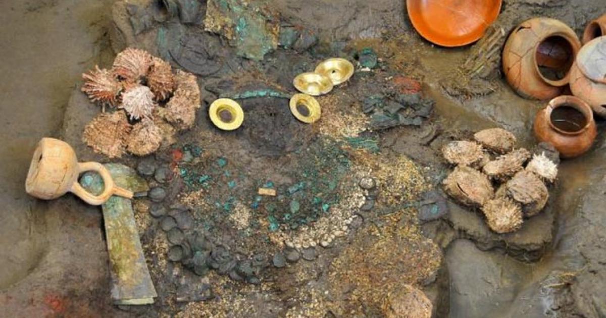 Gold earrings, two knives, a collection of shells, and ceramic containers were uncovered from a flooded Lambayeque tomb. 