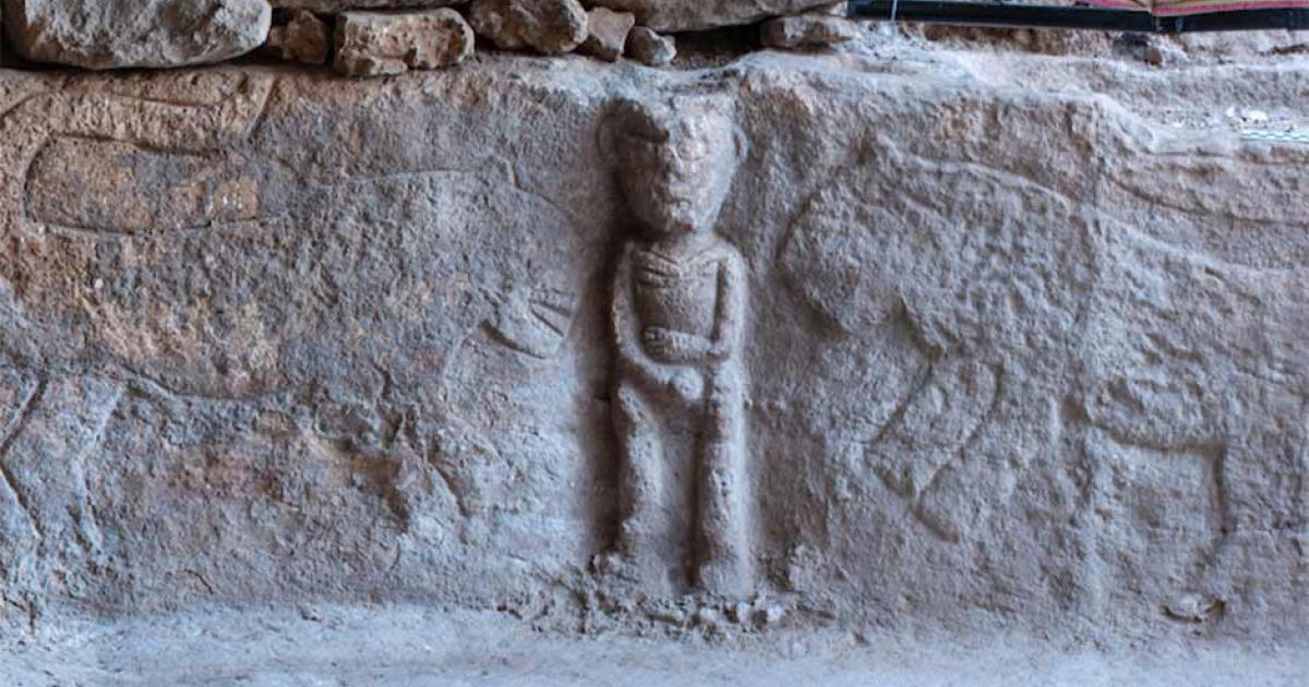 The right side of the Neolithic Anatolian stone relief depicting a male figure holding his phallus in the middle with leopards on either side.