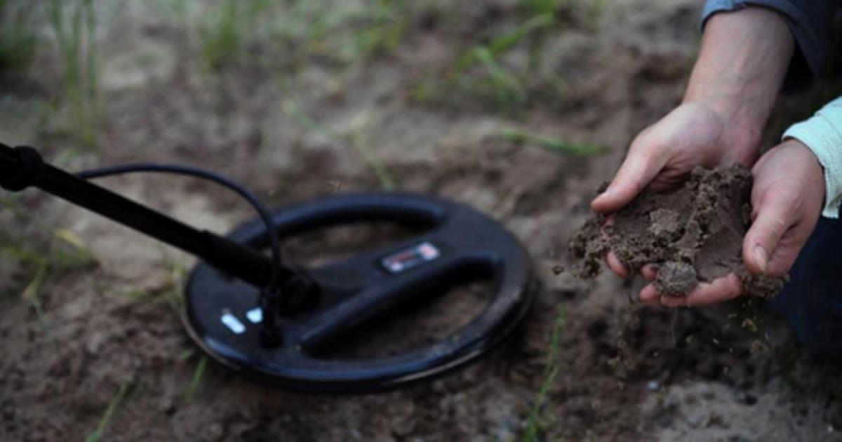 The treasure-hunters. Working with a metal detector. 