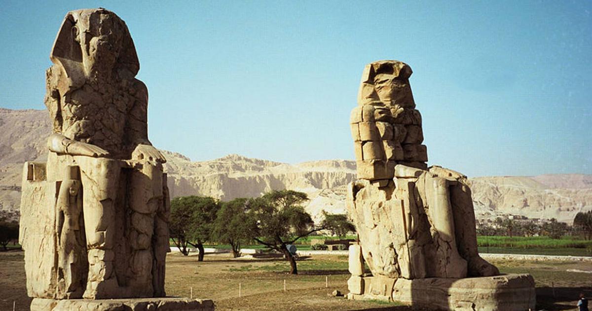 The twin seated Colossi of Memnon, statues of Amenhotep III, on the west back of Luxor, Egypt