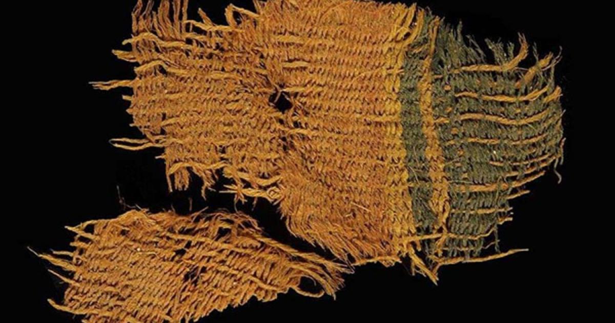 A fine wool textile dyed red and blue, found at Timna. The textile used the various colors of natural animal hair to create black and orange-brown colors for decorative bands. 