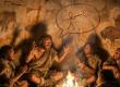 Early humans in a cave enjoying a humorous story.