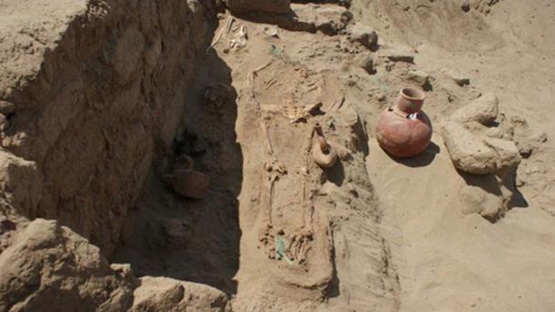 A Moche grave with the remains of a woman and a child and grave goods. (Deisy Cubas)