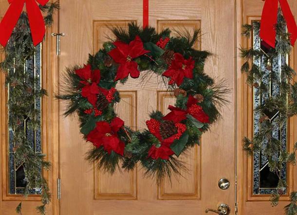 A door decorated with a Christmas wreath.