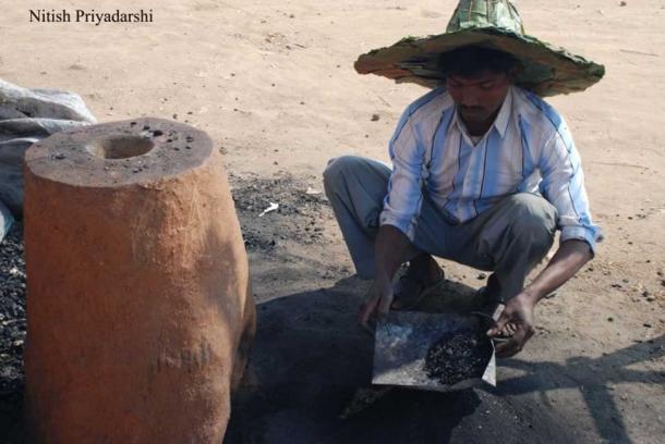 A modern Asur man using a traditional furnace to make iron in Ranchi city.