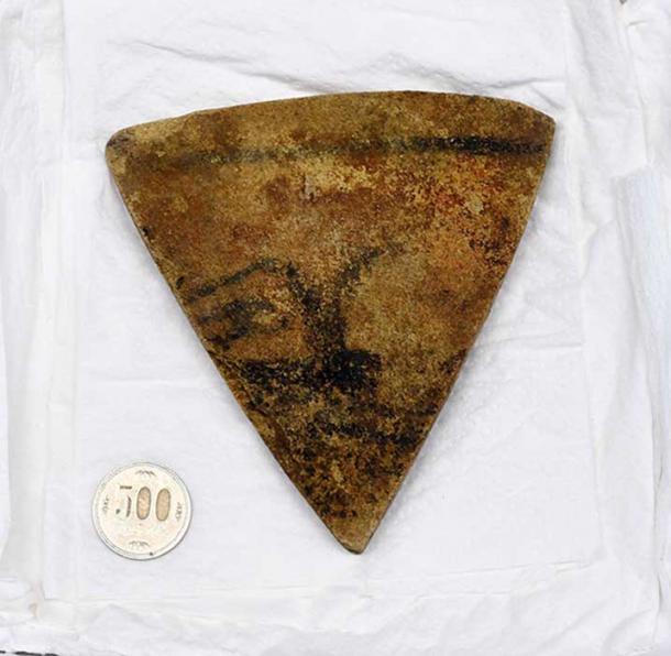 A stone piece bearing the painting of a human face and found in Kikonai, Hokkaido (Image: Yoshinori Toyomane)