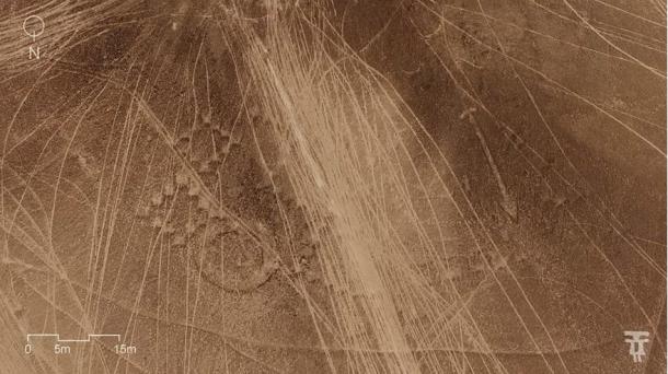 Aerial of more geoglyphs run through by tire tracks.