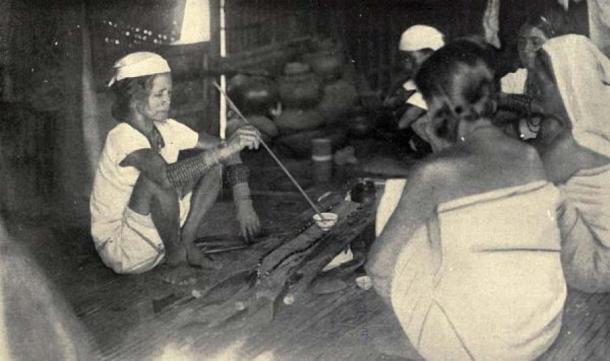 An Itneg shaman renewing an offering to the spirit shield (1922, Philippines). (Public Domain)