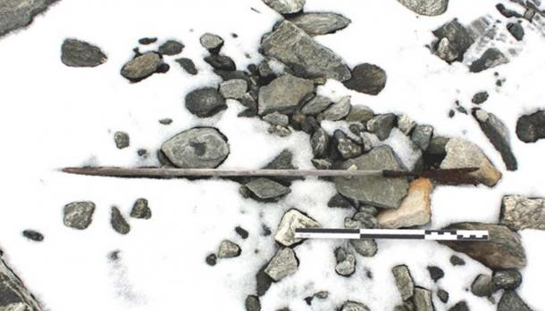 An arrow from 800 AD found on the ground, partly covered by snow. 