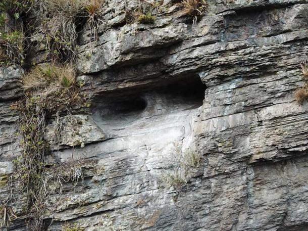 An opening in the cliff face appears to be hewn