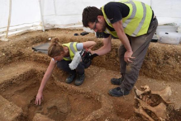Arqueólogos desenterrando el escudo guerrero junto con los restos del hombre (MAP Archaeological Practice Limited)