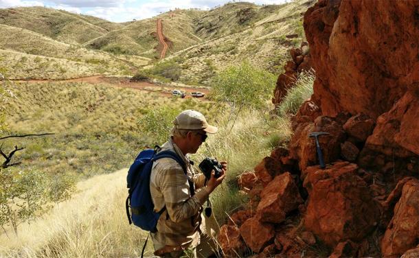 Benjamin Johnson of Iowa State University works at an outcrop in remote Western Australia where geologists are studying 3.2-billion-year-old ocean crust. (Image: Jana Meixnerova, provided by Benjamin Johnson /Iowa State University)