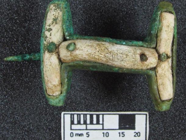 A Bronze brooch with coral decoration found at the site.