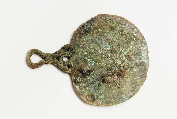 Bronze mirror found within the 2,000-year-old Iron Age burial of a female warrior on the Isles of Scilly. (Historic England Archive)