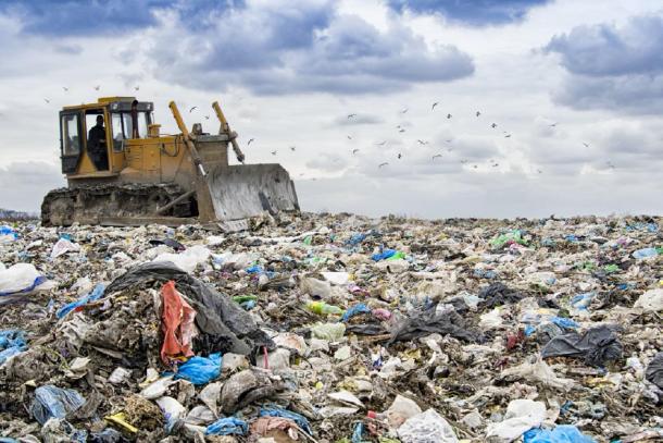 Bulldozer working to move waste showing the buildup of plastic on our planet. (Perytskyy / Adobe stock)
