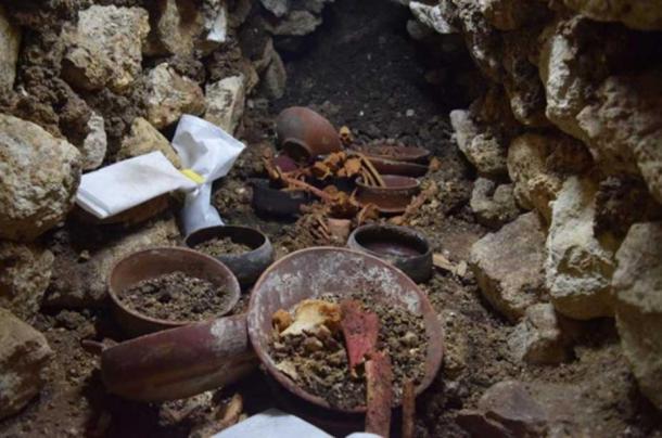 Burial 80 during excavation shows a stone cup in the center surrounded by bones