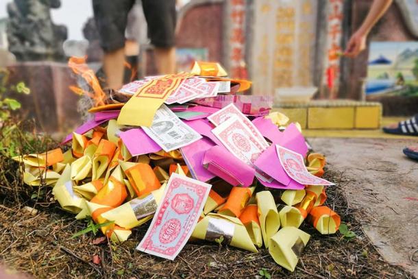 Burning money and offerings during the Qingming Festival. (ThamKC / Adobe Stock)