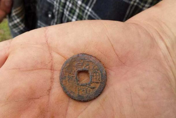 Ceramics, tools and materials were found about half a metre beneath the surface. This coin was found at a more recent site nearby. (Vietnam Maritime Archaeology Project)
