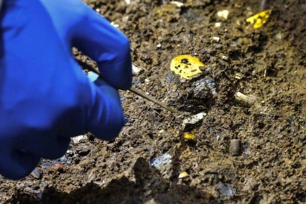 The hand of a Chinese archaeologist at the Baodun site, adjacent to the Chinese Sanxingdui Ruins, carefully unearthing carbonized bamboo fragments that once were part of a mud bamboo house believed to be 4,500 years old. (XinhuaNet)