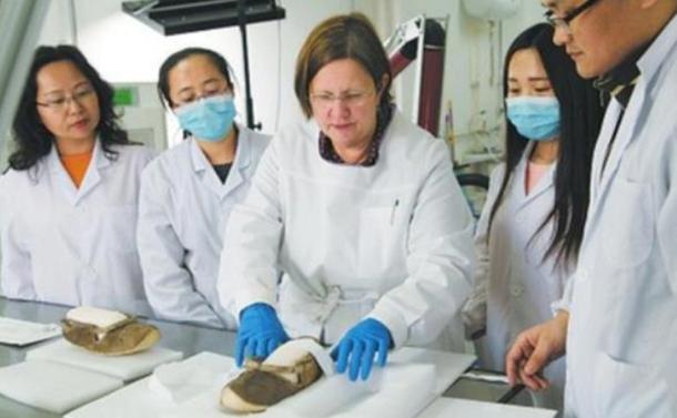 A Chinese archeological research institute restoring a pair of 1,400-year-old shoes unearthed from the Astana Tombs.
