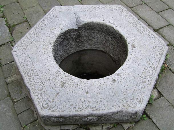 A Chinese carved stone well head.