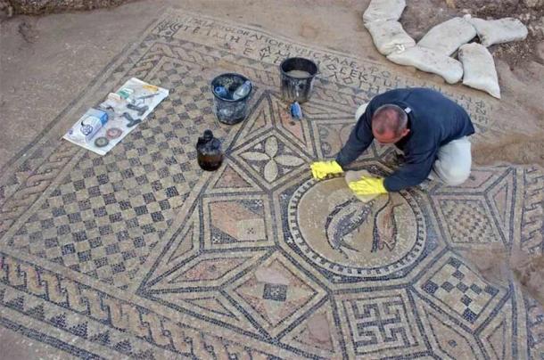 Trabajos de limpieza y conservación en curso en el mosaico de la prisión dentro de la prisión de Megiddo en Israel. (Dr. Yotam Tepper/Autoridad de Antigüedades de Israel)