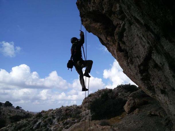 Climbing with ropes to reach the cave. (Image: Yoav Negev, courtesy Israel Antiquities Authority)