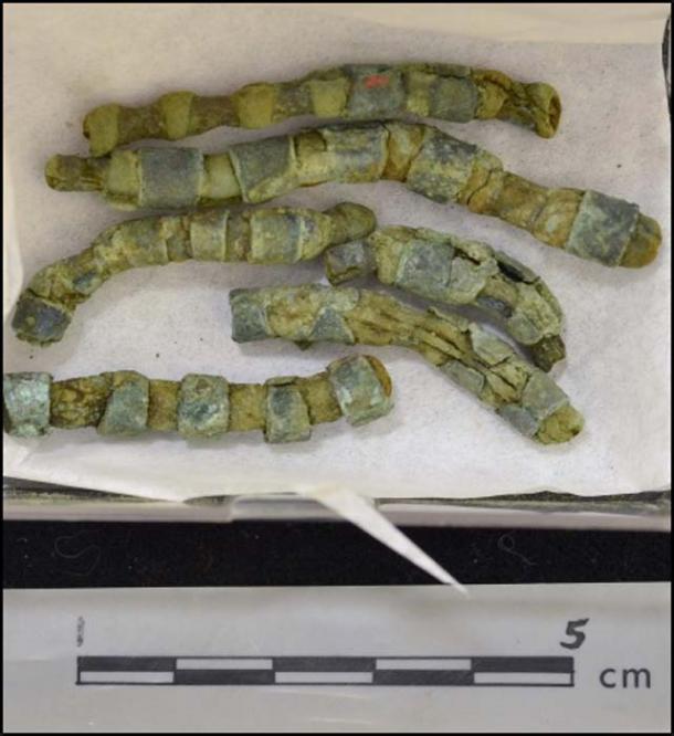 Copper adornment strips crimped onto organic material.