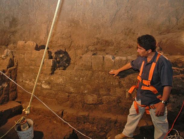 El director de la excavación, Sergio Gómez, inspecciona una parte de un muro de piedra que se encuentra en todo el túnel.  Una marca de agua alta que cubre todo el túnel y el área de la caverna es evidencia de que el agua fue un ingrediente importante en algunas reacciones químicas.