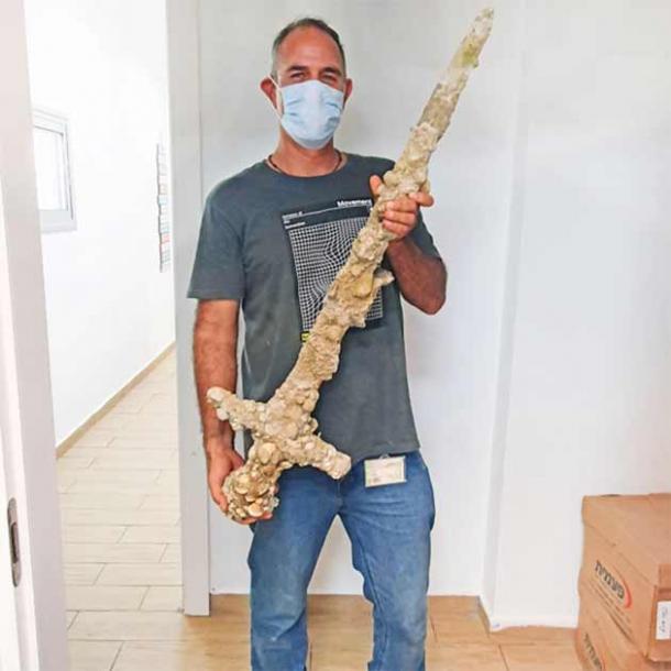 Diver Shlomi Katzin with the 900-year-old Crusader sword. (Nir Distelfeld / Israel Antiquities Authority)