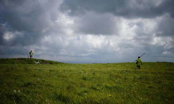 Dr. Catherine Frieman in a field in Cornwall with survey equipment. Image: ANU
