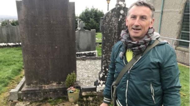 Dr Gerry Quinn at the grave of Reverend James McGirr (Credit: BBC)
