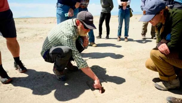 Daron Duke, del Grupo de Investigación Antropológica del Lejano Oeste, muestra las huellas de los visitantes descubiertas en un sitio arqueológico en el Campo de Pruebas y Entrenamiento de Utah en julio de 2022. (R. Nial Bradshaw/Fuerza Aérea de EE. UU.)