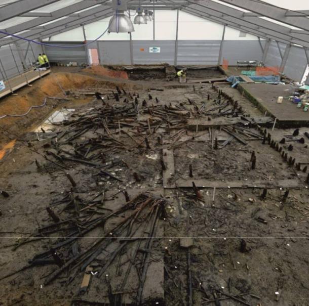 Excavation of the Must Farm pile-dwelling settlement, showing the main body of the collapsed settlement (looking east) in its river silt matrix.