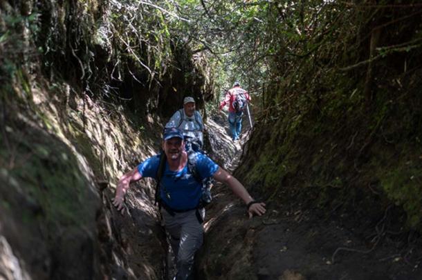 Expedition members clamber along an access trail to the mountain