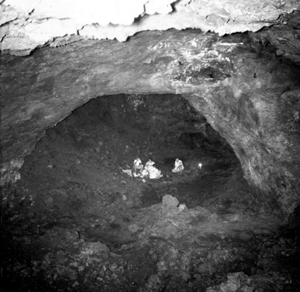 Falemauga Caves, an archaeological site in Samoa, photo showing large chamber with a small group of people inside. (Public Domain)