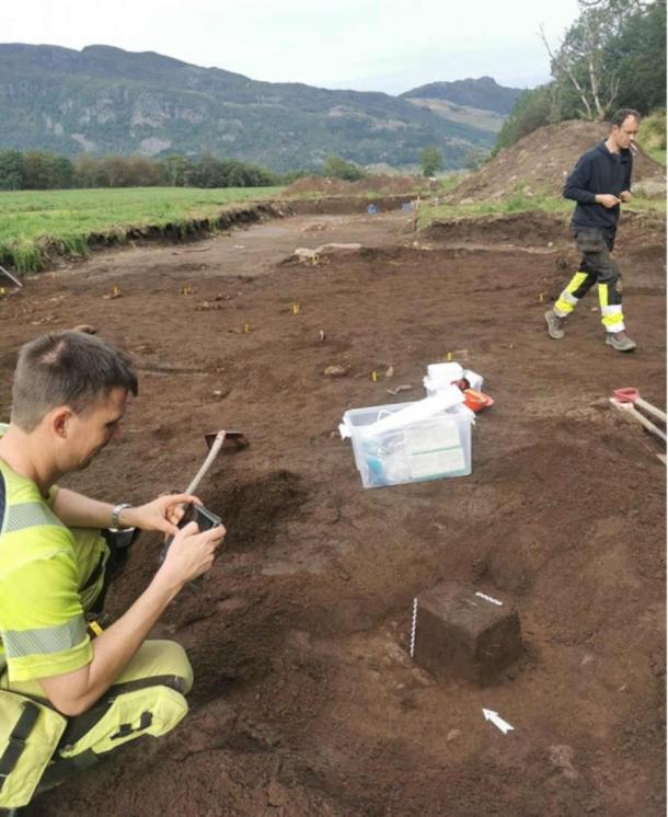 Field archaeologists Ola Tengesdal Lygre (left) and Theo Eli Gil Bell at the silver treasure. It was taken out as a block and transported to the museum for further analysis. (Volker Demuth, Archaeological Museum/ University of Stavanger)