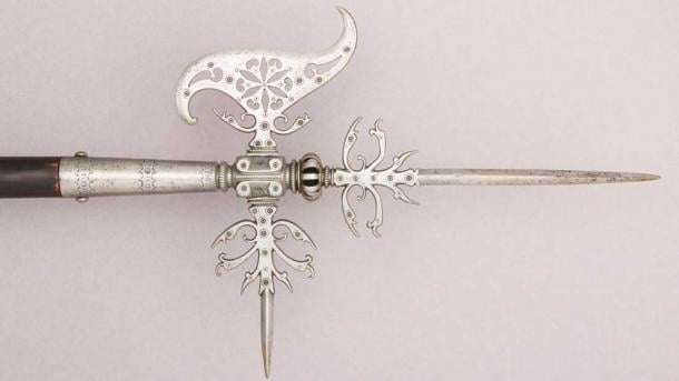 A Flemish halberd, c.  17th century.  A halberd is a two-handed polearm consisting of an ax blade topped with a spike mounted on a long handle.  It still has a hook or thorn on the back of the ax blade to grab mounted combatants (Metropolitan Museum of Art / Public Domain).