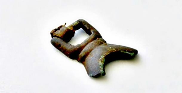 Fragment recovered from a brass buckle of the Thule culture that still retains some of its leather strap